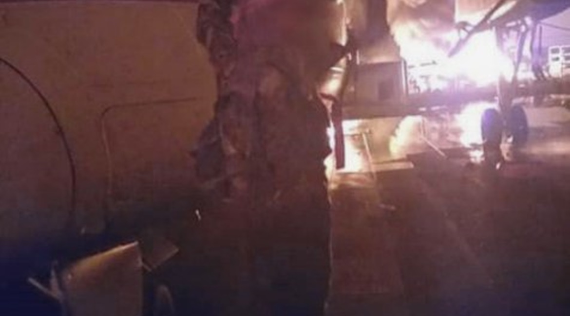 A militant waves a black flag in front of a burning DHC-8 aircraft at Manda Bay airfield in a photograph released by Al-Shabaab on 5 January. AFRICOM said at the time that six aircraft had reportedly been damaged in the attack.