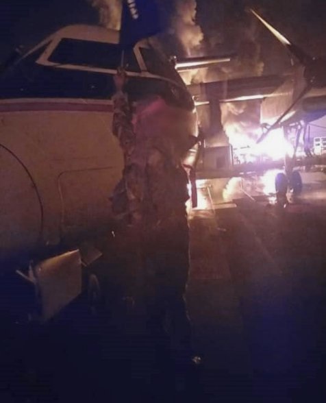A militant waves a black flag in front of a burning DHC-8 aircraft at Manda Bay airfield in a photograph released by Al-Shabaab on 5 January. AFRICOM said at the time that six aircraft had reportedly been damaged in the attack.