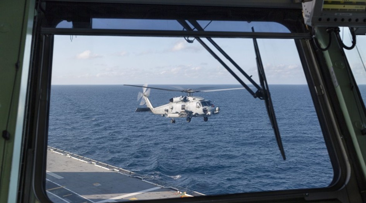 A RAN MH-60R helicopter prepares to land onboard HMAS 
        
         as it departs Sydney for first-of-class flight trials.