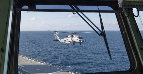 A RAN MH-60R helicopter prepares to land onboard HMAS 
        
         as it departs Sydney for first-of-class flight trials.