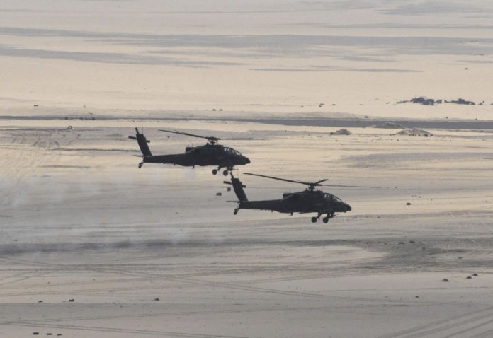 Two Egyptian Air Force AH-64D Apache attack helicopters are seen in a photograph released by the Egyptian MoD in February 2018. The country is set to upgrade its fleet of 43 such helicopters to the latest AH-64E standard, according to the DSCA.