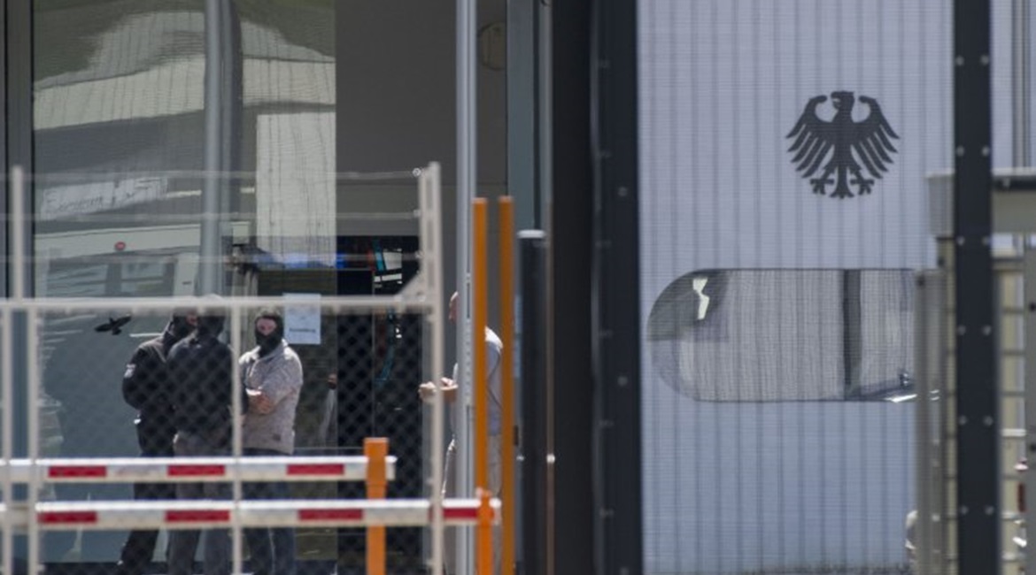 Masked policemen are seen on the grounds of the Federal Supreme Court (Bundesgerichtshof) in Karlsruhe, southern Germany, on 15 April after five Tajiks suspected to be members of an Islamic State terrorist cell were arrested. German police had arrested...