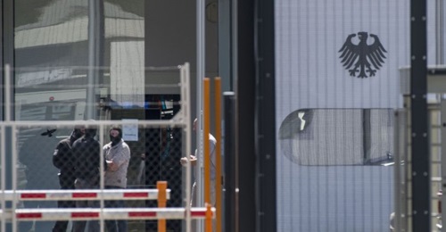 Masked policemen are seen on the grounds of the Federal Supreme Court (Bundesgerichtshof) in Karlsruhe, southern Germany, on 15 April after five Tajiks suspected to be members of an Islamic State terrorist cell were arrested. German police had arrested...