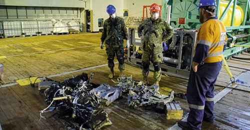 Canadian Armed Forces members and EDT Hercules personnel inspect recovered parts of CH-148 Cyclone on 31 May 2020 during recovery operations for the aircraft.