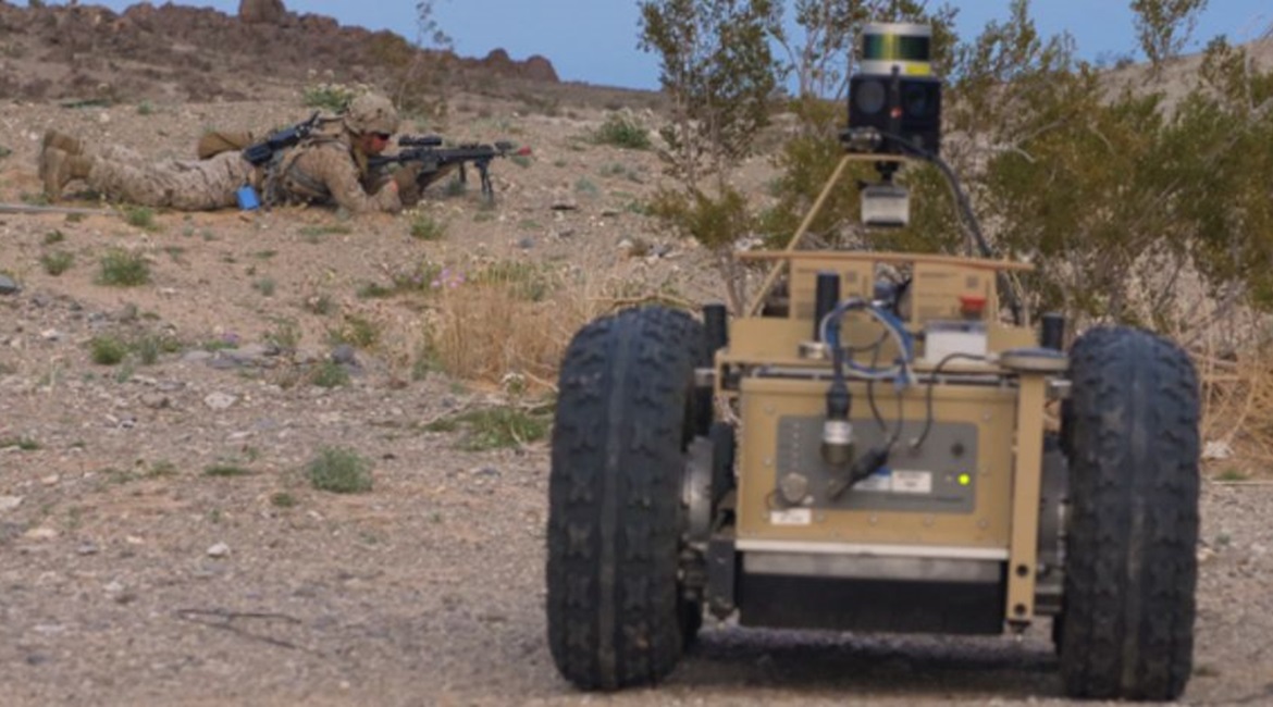 A US Marine Corps infantryman sets up a firing position while covered by an unmanned ground vehicle during field drills for DARPA's Squad X programme, held at the Air Ground Combat Center in Twentynine Palms, California.