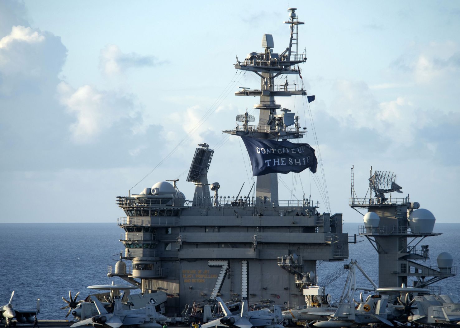 
        The aircraft carrier USS 
        Theodore Roosevelt
         (CVN 71) flies a ‘Don’t give up the ship’ flag as it gets underway following a Covid-19 outbreak. 
       (US Navy)