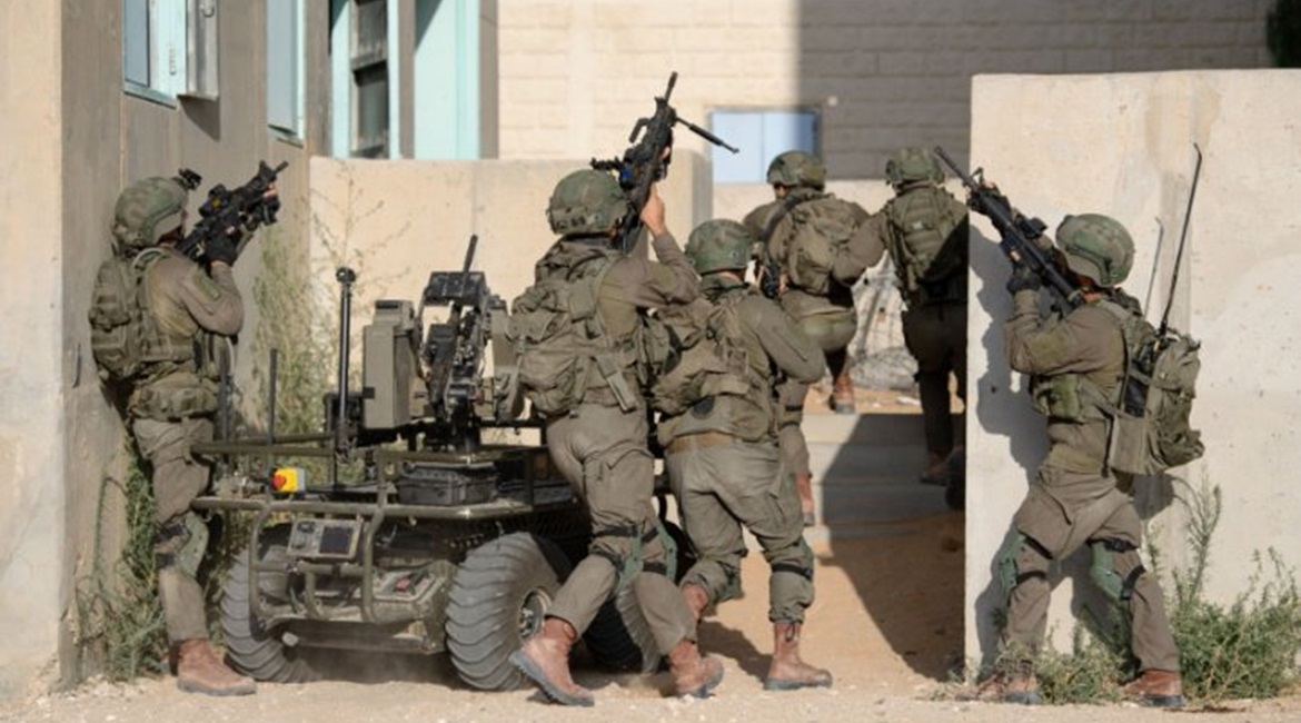 Soldiers from the Multi-Dimensional Unit practice storming a building with an unmanned ground vehicle.