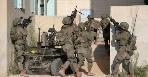 Soldiers from the Multi-Dimensional Unit practice storming a building with an unmanned ground vehicle.