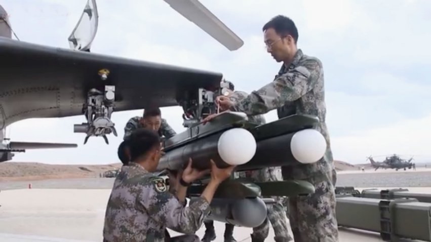A screengrab from CCTV 7 footage released online on 6 August showing two units of a new ATGM being loaded onto one of the launchers of a PLAGF Z-10 attack helicopter. The launcher is also carrying what appears to be a pod. (Via js7tv.cn)