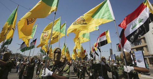 Masked Kataib Hizbullah fighters parade in Baghdad in May 2019.