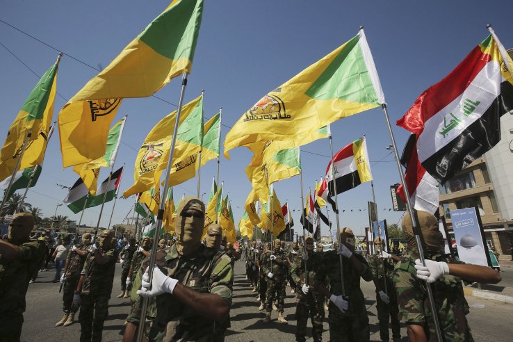 Masked Kataib Hizbullah fighters parade in Baghdad in May 2019.  (Getty Images)