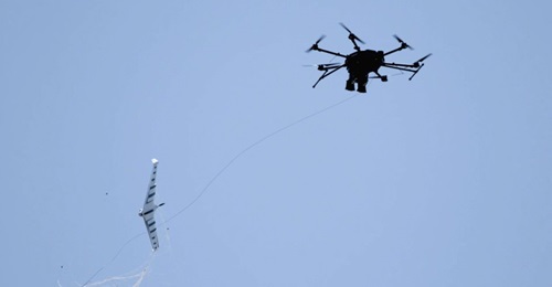 Fortem Technologies' DroneHunter UAS (right) uses its NetGun net attached to a tether to capture an enemy UAS.