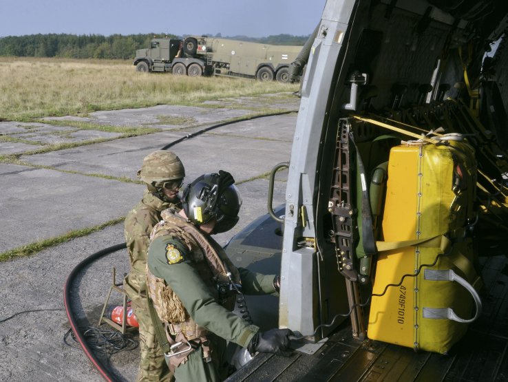 A Merlin crew member and ground support personnel refuel the helicopter during a deployment exercise. The UK MoD is looking to reduce the reliance on fossil fuels for its aircraft fleets as part of a wider UK government drive towards more sustainable fuels. (Janes/Patrick Allen)