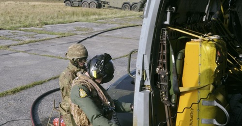 A Merlin crew member and ground support personnel refuel the helicopter during a deployment exercise. The UK MoD is looking to reduce the reliance on fossil fuels for its aircraft fleets as part of a wider UK government drive towards more sustainable f...