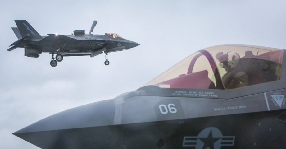 
        A UK F-35B in the hover prior to landing aboard HMS
        Queen Elizabeth
        while a USMC aircraft taxies along the flight deck. The commanders of both 617 Squadron and VFMA 211 described the recent joint training mission as being ‘seamless’ between them.
       (Crown Copyright)