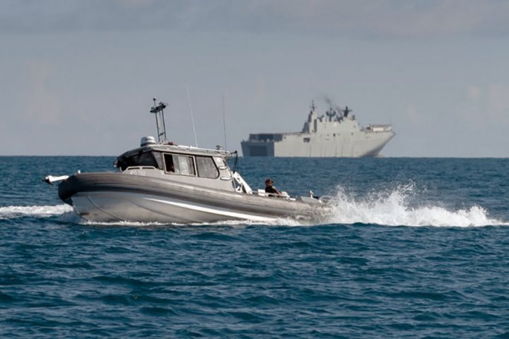 
        The RAN announced on 8 November that its Maritime Geospatial Warfare Unit recently deployed for the first time a new type of small survey craft (foreground) from its Canberra-class amphibious assault ship HMAS
        Adelaide
        (background) as part of Exercise ‘Sea Wader 2020’.
       (RAN)