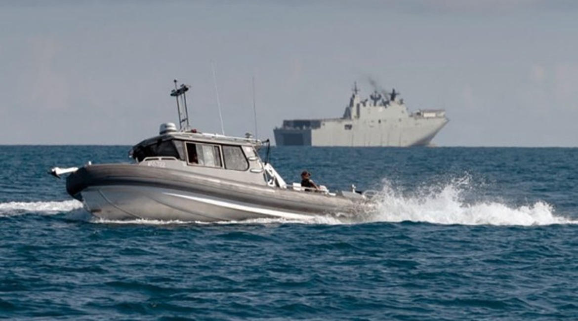 The RAN announced on 8 November that its Maritime Geospatial Warfare Unit recently deployed for the first time a new type of small survey craft (foreground) from its Canberra-class amphibious assault ship HMAS 
        
         (background) a...
