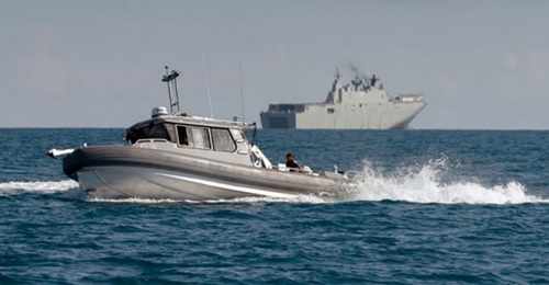 The RAN announced on 8 November that its Maritime Geospatial Warfare Unit recently deployed for the first time a new type of small survey craft (foreground) from its Canberra-class amphibious assault ship HMAS 
        
         (background) a...