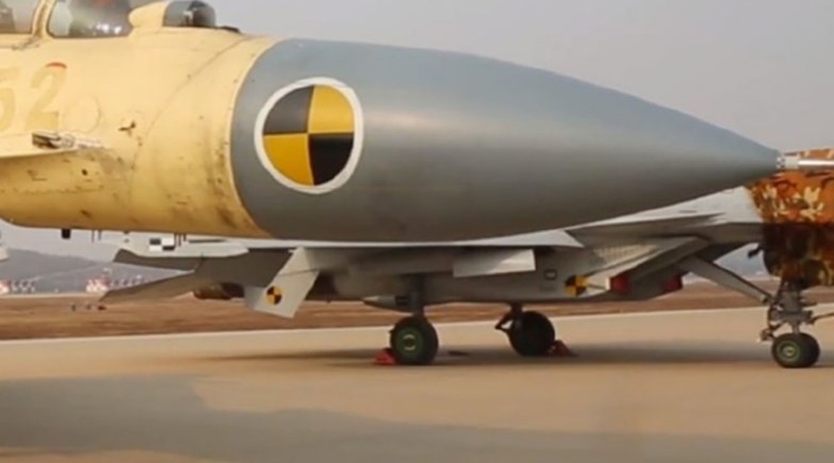 A still from footage released by CNR on 17 November showing part of a CATOBAR-capable J-15T (background, painted in grey) at China's test facility at Huangdicun Airbase.