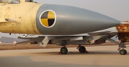 A still from footage released by CNR on 17 November showing part of a CATOBAR-capable J-15T (background, painted in grey) at China's test facility at Huangdicun Airbase.