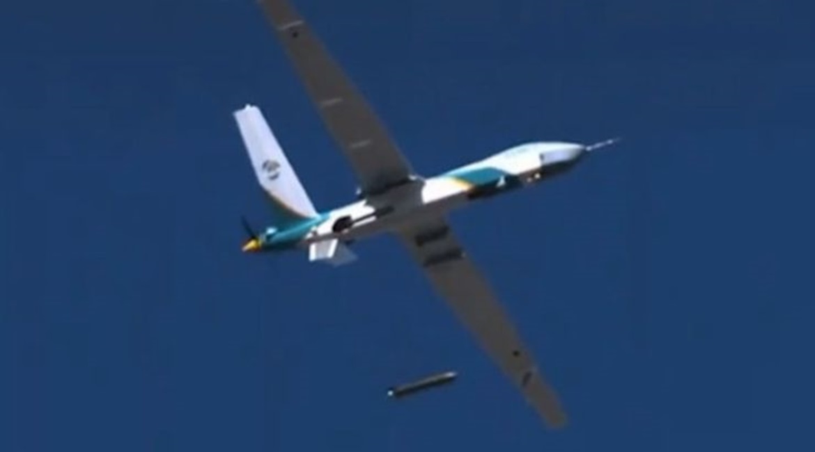 A Wing Loong-series UAV in flight dropping a munition-shaped canister carrying supplies.