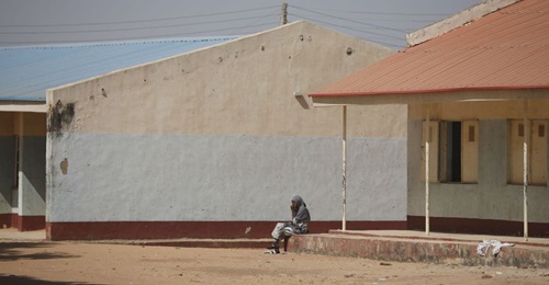 A parent sits outside the Government Science Secondary School in Kankara in Nigeria's northwestern state of Katsina, where gunmen kidnapped more than 300 schoolboys on 11 December 2020.