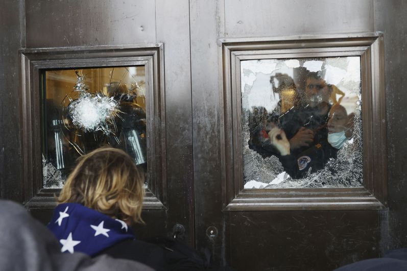 A photograph depicting pro-Trump protesters attempting to enter the Capitol Building, glass on the doors of which has been damaged. (Tasos Katopodis via Getty Images.)