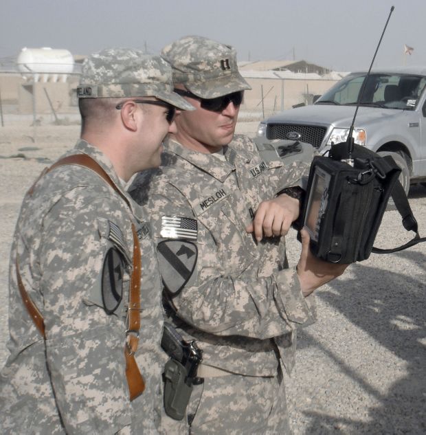 A US Army electronic warfare officer with the 103rd Sustainment Command (Expeditionary) discusses the measurements on a handheld spectrum analyser collected during combat operations in Iraq.  (US Army )