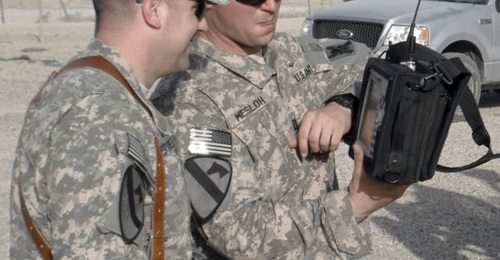 A US Army electronic warfare officer with the 103rd Sustainment Command (Expeditionary) discusses the measurements on a handheld spectrum analyser collected during combat operations in Iraq.