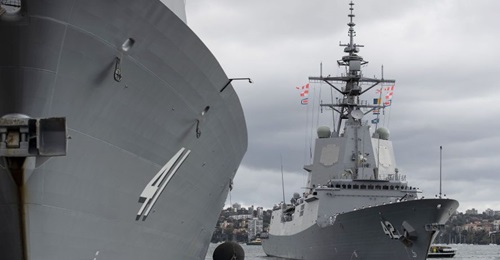 HMAS Sydney (right) departing Fleet Base East for its combat systems trials.