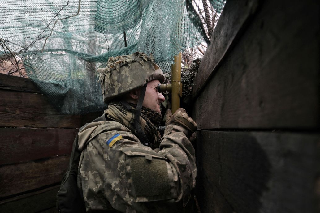 A Ukrainian soldier uses a periscope on the front line with Russian-backed separatists near Marinka, Donetsk, on 20 April. (Aleksey Filippov/AFP via Getty Images)
