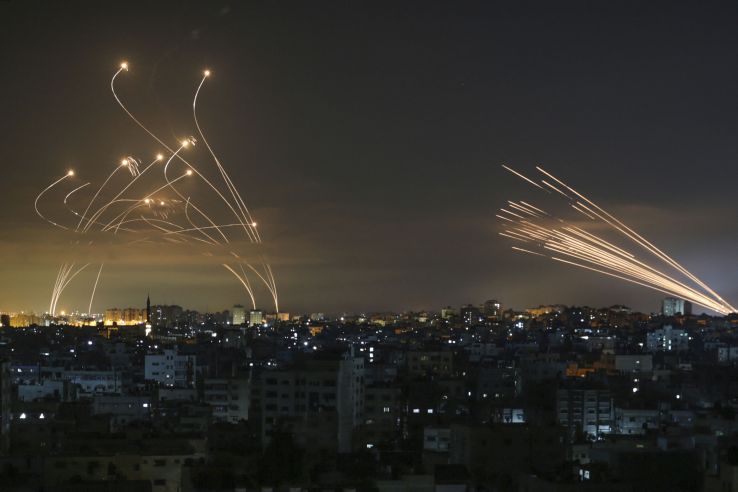 Iron Dome launchers in southern Israeli fire Tamir interceptors (left) against a barrage of rockets coming from the Gaza Strip, the contrails of which can be seen (right) on the night of 14 May. (Anas Baba/AFP via Getty Images)